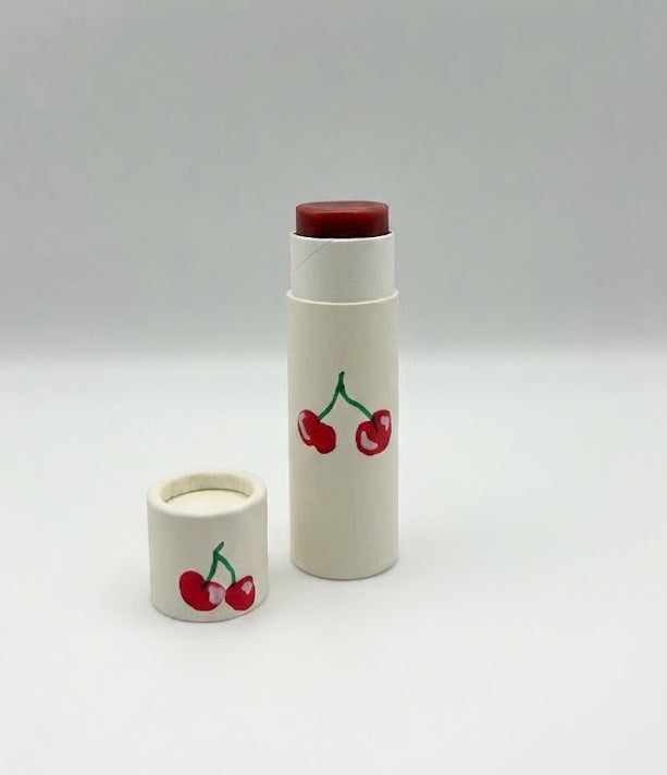 Two lip balm containers with cherry designs on a white background